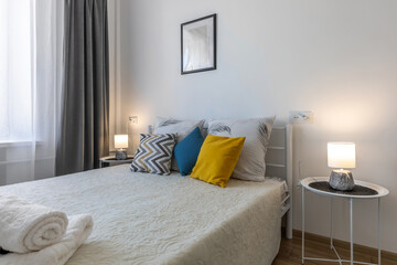 Minimalist Bedroom with Pillows, Towels and Cozy Lighting