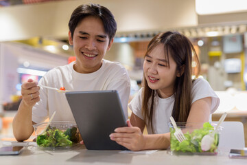 Young couple eating salad in restaurant