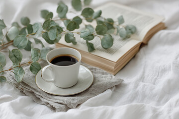 Still life in boho style of a artisan cup of coffee next to a book
