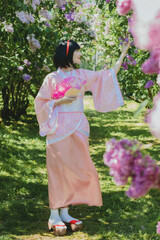 Dreamy portrait of a mysterious geisha-cosplay inspired beauty. Porcelain-skinned woman in a pink...