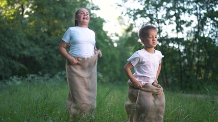 Two children a field. Children race in the grass outside in summer. A girl and boy are having fun in nature. Two kids in a meadow lifestyle.