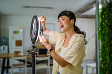 female japanese video blogger set up equipment and prepare for filming