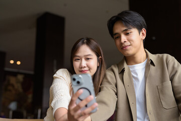 portrait of a happy young couple taking selfie in cafe