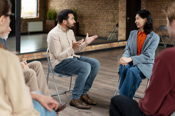 Psychologist leading group therapy session for people coping with addiction