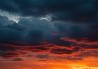 Obraz premium Dramatic sky with dark clouds and orange sunset light, creating a beautiful contrast