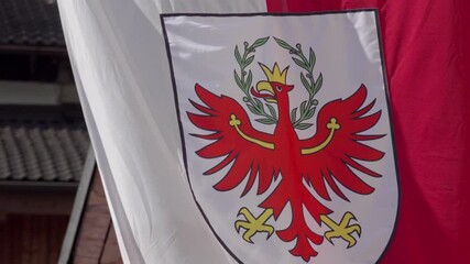 A portion of the South Tyrolean flag, showing the iconic red eagle, flutters in the wind. A powerful symbol of regional identity and cultural pride.
