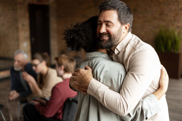 Psychotherapist is hugging patient during a group therapy session