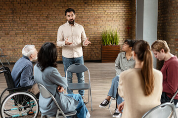 Counselor leading group therapy session for people with disabilities
