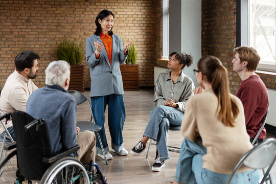 Asian businesswoman leading diverse team meeting in modern office