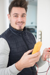 young electrician holding a multimeter