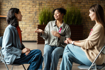 Women supporting each other during breast cancer awareness campaign meeting