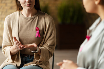 Woman with pink ribbon talking about breast cancer awareness