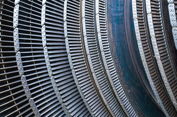 detailed metal fins and segments forming the curved structure of an industrial turbine or engine component, showcasing repetitive mechanical patterns and riveted joints