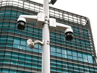 Paris, France - May 4, 2025: Modern surveillance cameras mounted on a pole in front of a curved...