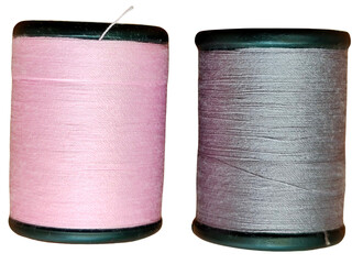 Two spools of thread, one pink and one gray, standing upright with visible thread texture wrapped...