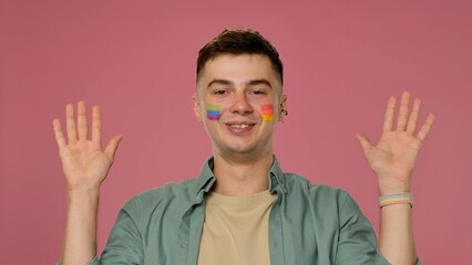 Smiling Individual with Colorful Face Paint and Raised Hands