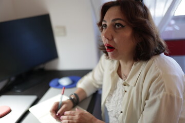 Businesswoman taking notes and looking up with an amazed expression