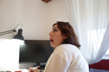 Woman working from home is having a revelation while taking notes