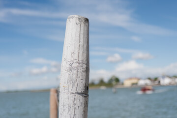 Majestic waterfront view captured with focus on a weathered post at noon
