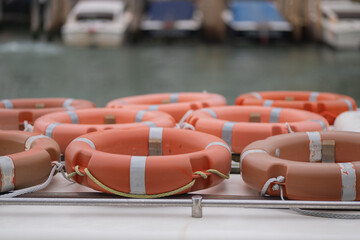 Bright lifebuoys resting on a boat anchored by the serene harbor waters
