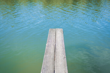 Relaxing view from a wooden pier over calm turquoise water at midday