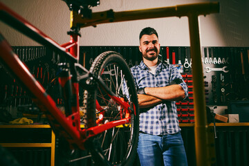 Mechanic smiling with arms crossed in bicycle repair shop