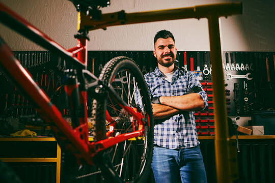 Mechanic smiling with arms crossed in bicycle repair shop