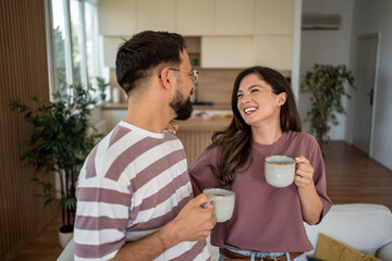 Happy couple enjoying coffee together in modern apartment