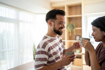 Happy couple sharing a moment while drinking coffee at home
