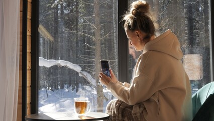 Woman in hut takes photo with her phone showing how even distant shoots remain connected Phone...
