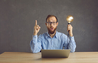 Excited man freelancer with amazed facial expression brainstorming having creative online business...