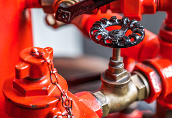 Close-up view of a vintage brass valve against a vibrant red background showcasing intricate design and craftsmanship