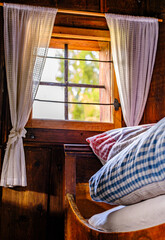 Cozy bed with checkered pillows in a rustic wooden cabin during a serene afternoon