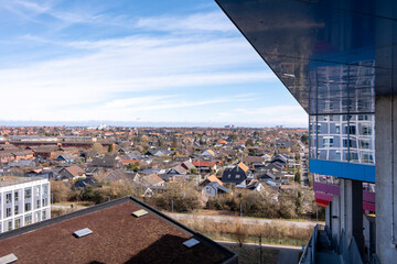 Contemporary apartments and vegetation rooftops in Ørestad, Copenhagen, captured from above with layers of suburban development and soft atmospheric light