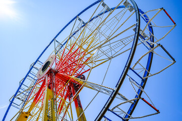 Ferris wheel illuminated at dusk with vibrant colors against a cloudy sky in a festive atmosphere