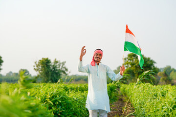 indian farmer waving national tricolor flag at agriculture field