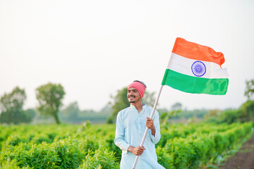 indian farmer waving national tricolor flag at agriculture field