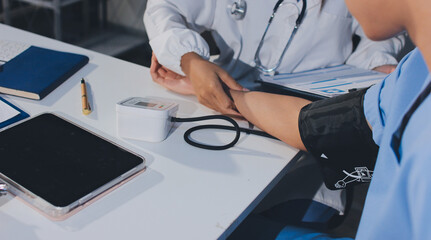 Doctor checking patient arterial blood pressure in hospital. Health care Concept
