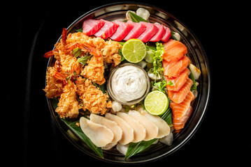 Grilled and raw seafood platter with shrimp, tuna, salmon, white fish, lime slices, dipping sauce,...