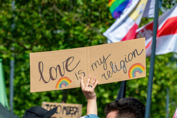 Protest sign with 'love is my religion' message at inclusive event