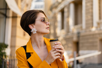stylish elegant woman in city street wearing bright colorful yellow suit summer style