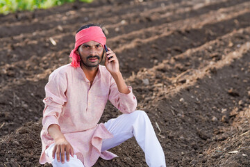 Young indian farmer talking at agriculture field