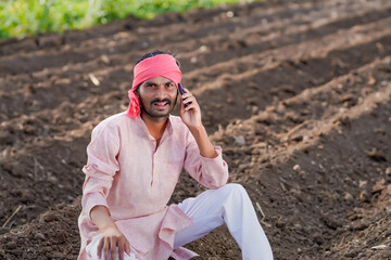 Young indian farmer talking at agriculture field