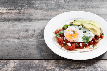 Huevos Rancheros on wooden table.Copy space. Traditional Mexican breakfast.	