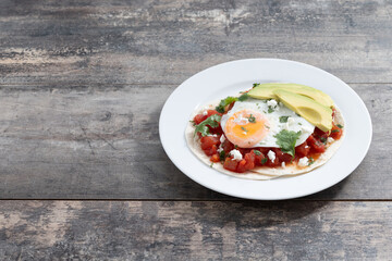 Huevos Rancheros on wooden table.Copy space. Traditional Mexican breakfast.	