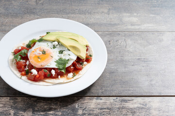 Huevos Rancheros on wooden table.Copy space. Traditional Mexican breakfast.	