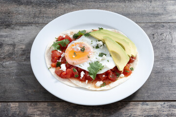 Huevos Rancheros on wooden table. Traditional Mexican breakfast.	