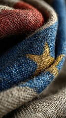 Woven fabric depicting a colorful star pattern in red, blue, and yellow with intricate textile details captured in natural light