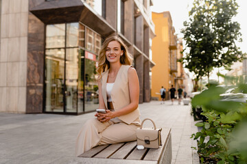 woman sitting in city street with phone