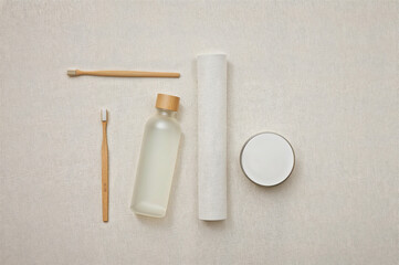 Zero Waste Travel Kit Flat Lay with Bamboo Toothbrush and Eco Essentials on Beige Fabric
